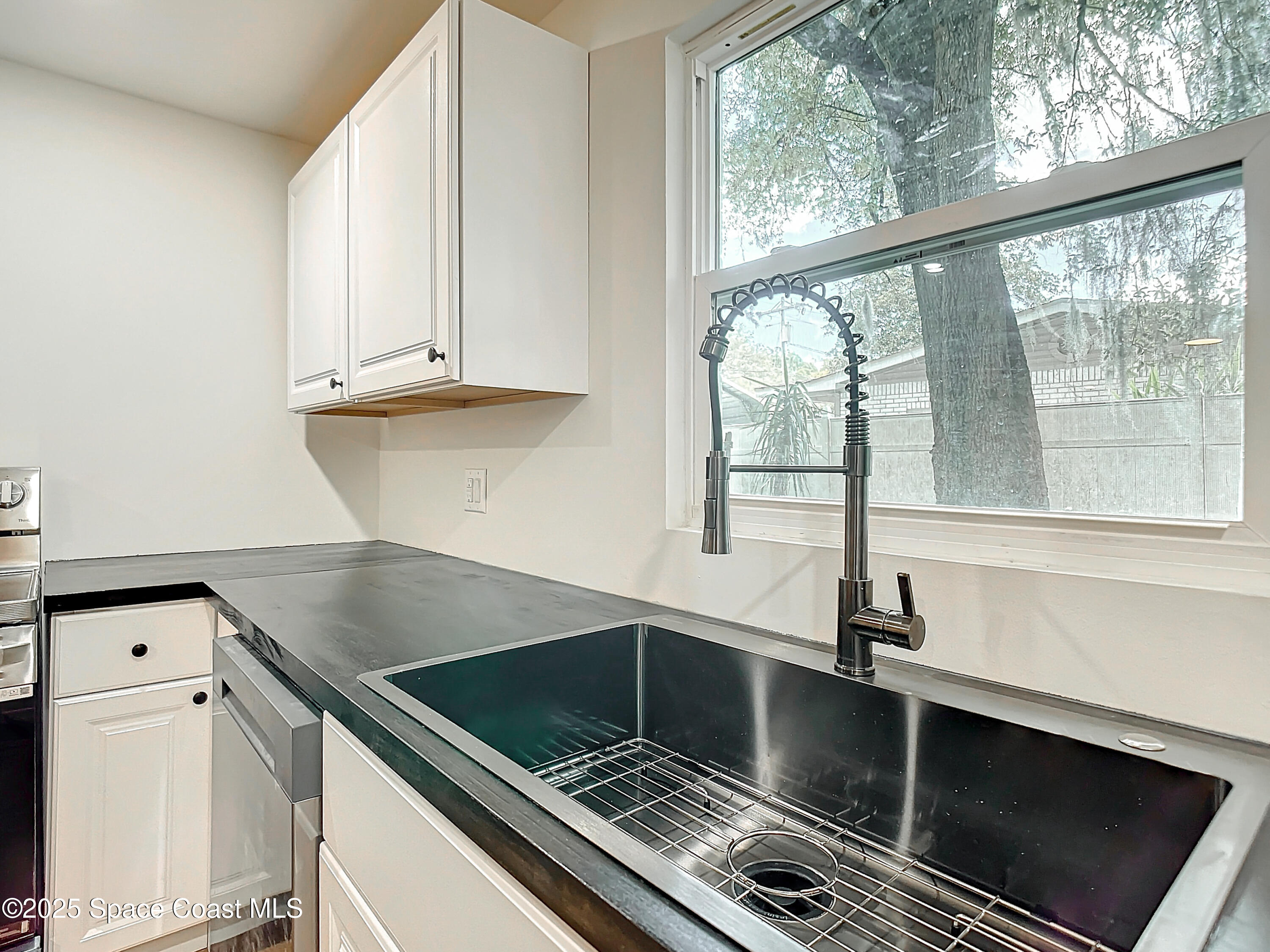 392 Arora Boulevard Orange Park, FL 32073 - Photo 8 of 45 a kitchen with a large window sink and cabinets