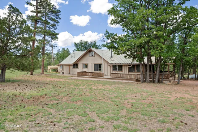 a front view of a house with a yard and trees