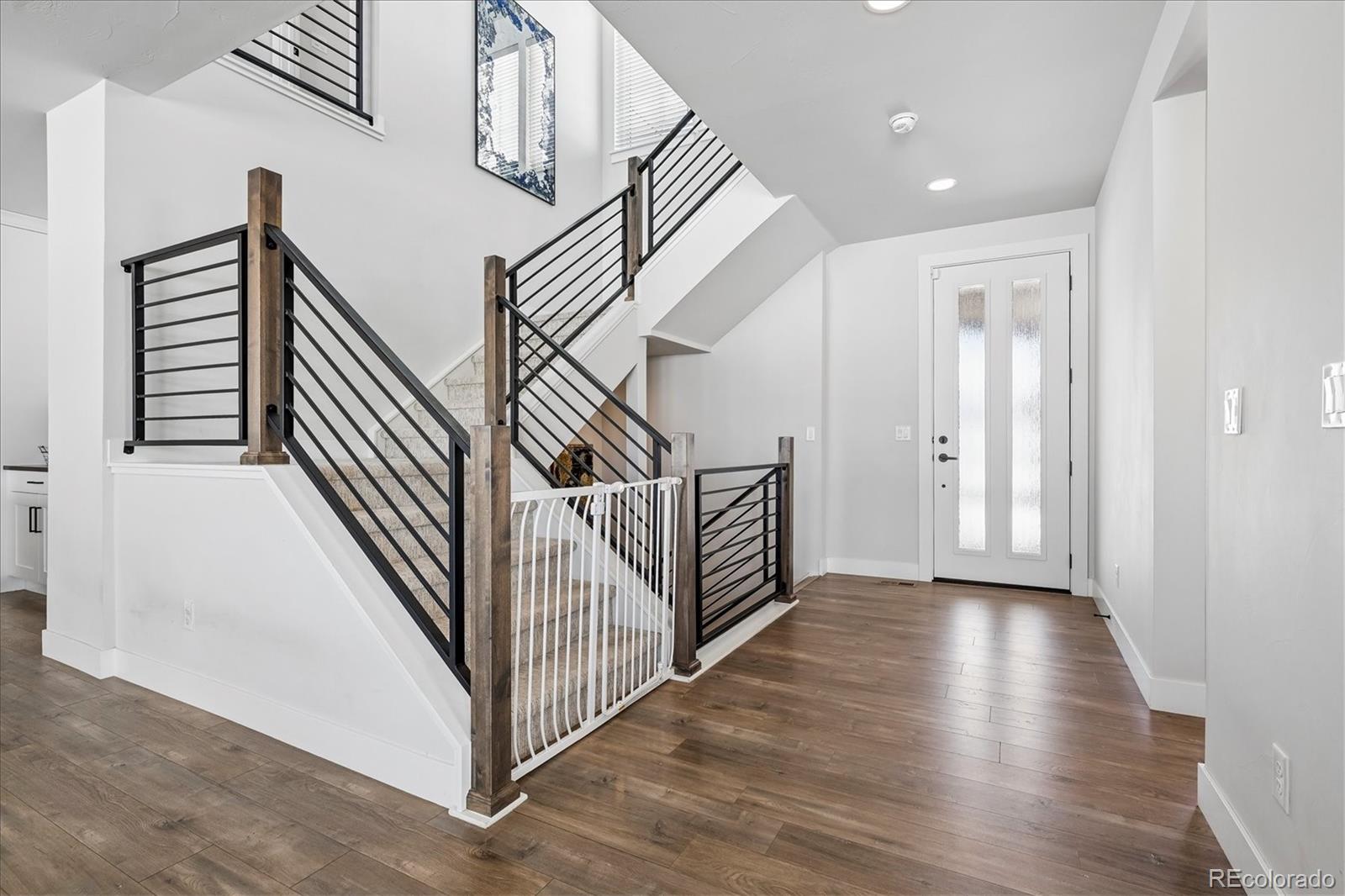 5601 Raintree Drive Parker, CO 80134 - Photo 41 of 50 a view of a hallway with stairs and wooden floor