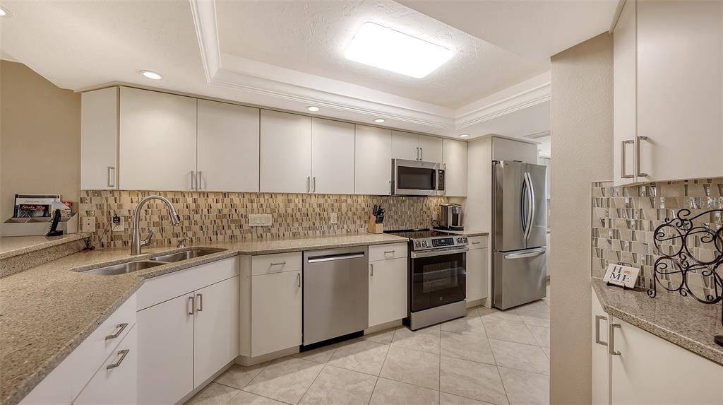 5780 Midnight Pass Road, Unit 207 Sarasota, FL 34242 - Photo 14 of 35 a kitchen with stainless steel appliances granite countertop a sink and stove top oven