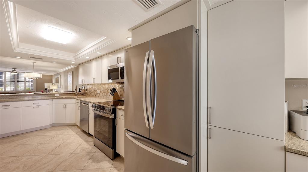5780 Midnight Pass Road, Unit 207 Sarasota, FL 34242 - Photo 16 of 35 a kitchen with stainless steel appliances granite countertop a refrigerator and a sink