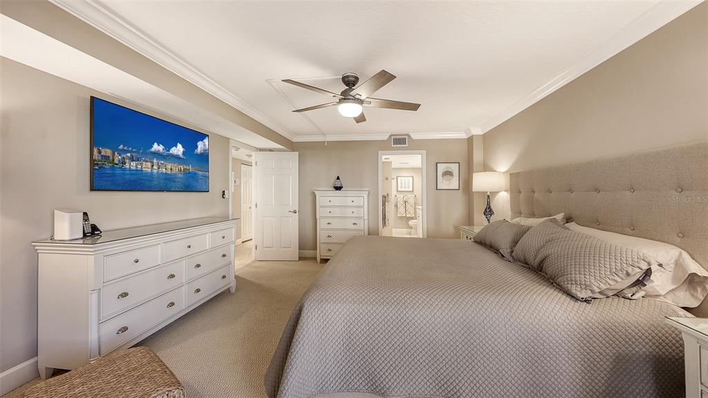 5780 Midnight Pass Road, Unit 207 Sarasota, FL 34242 - Photo 19 of 35 a bedroom with a bed and a flat screen tv
