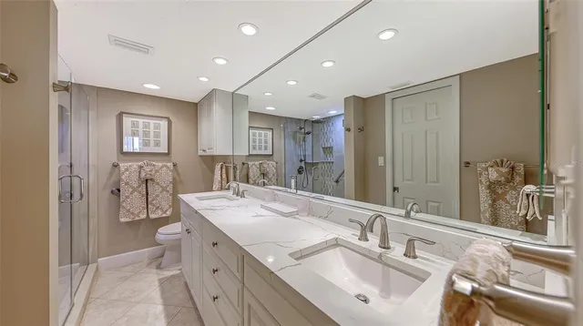 a bathroom with a sink double vanity granite tub shower and a mirror