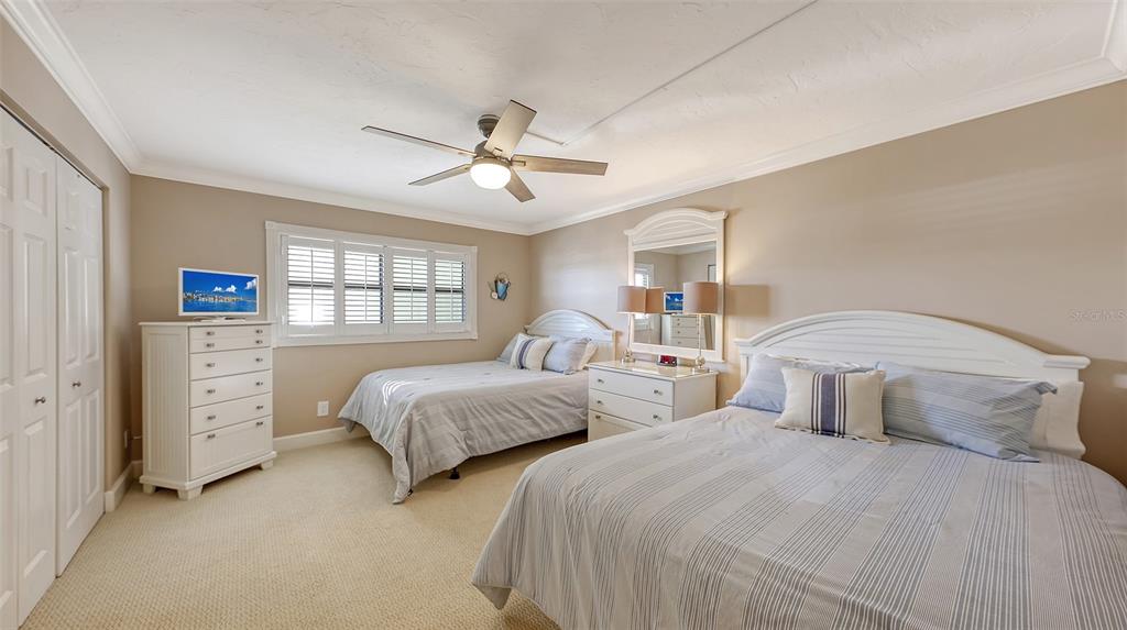 5780 Midnight Pass Road, Unit 207 Sarasota, FL 34242 - Photo 22 of 35 a bedroom with two beds and a chandelier