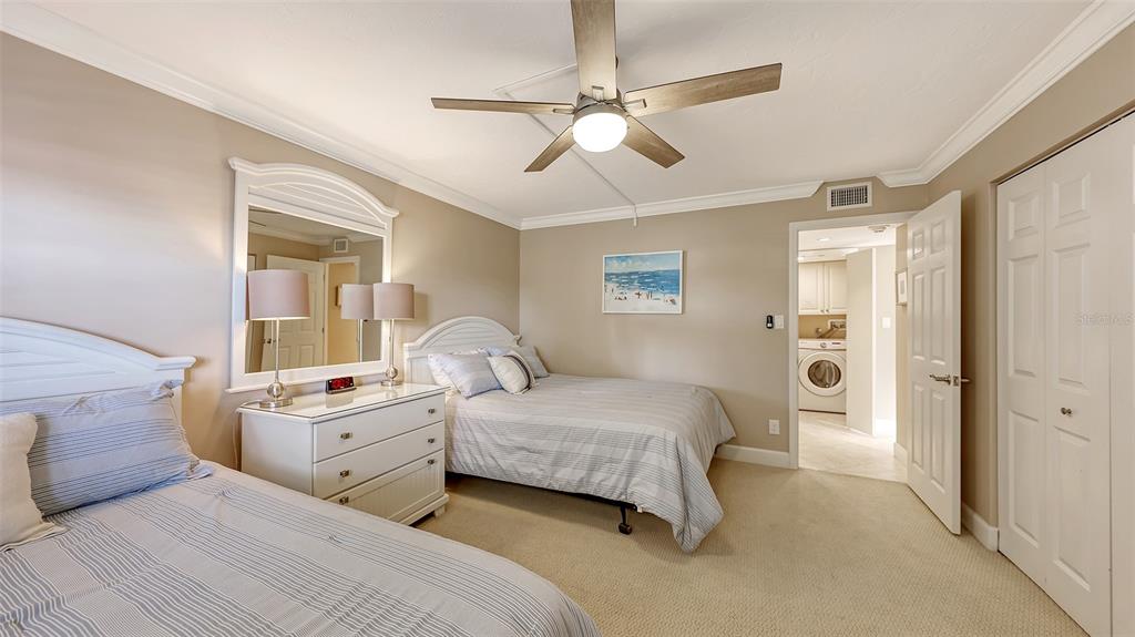 5780 Midnight Pass Road, Unit 207 Sarasota, FL 34242 - Photo 23 of 35 a bedroom with a bed and a chandelier