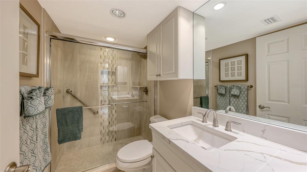 5780 Midnight Pass Road, Unit 207 Sarasota, FL 34242 - Photo 25 of 35 a bathroom with a granite countertop sink toilet a mirror a vanity and shower