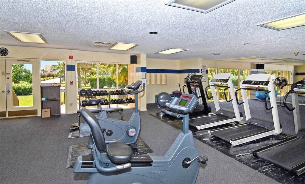 5780 Midnight Pass Road, Unit 207 Sarasota, FL 34242 - Photo 30 of 35 a room with gym equipment and floor to ceiling window