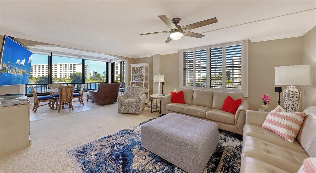 5780 Midnight Pass Road, Unit 207 Sarasota, FL 34242 - Photo 5 of 35 a living room with furniture a chandelier and a window