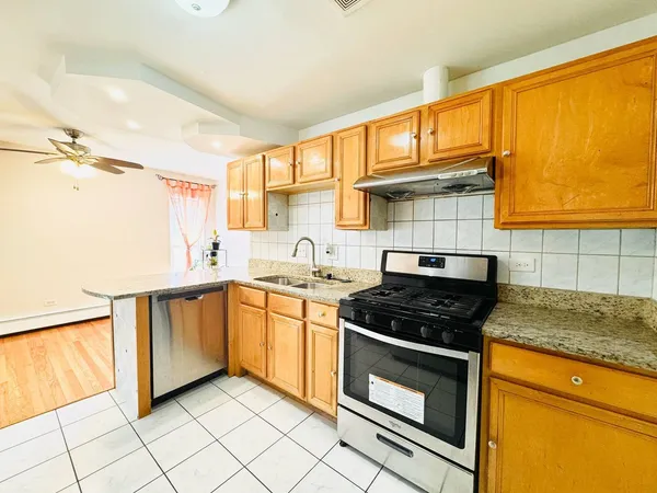 a kitchen with stainless steel appliances granite countertop a stove a sink and a microwave