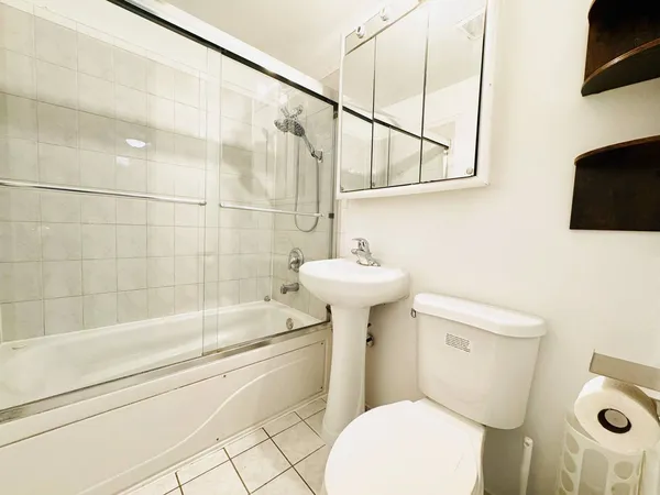 a bathroom with a sink a toilet a mirror and shower