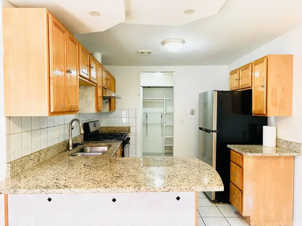 a kitchen with sink refrigerator and counter top space