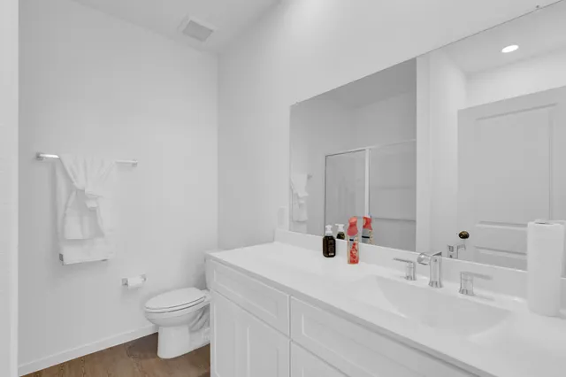 a bathroom with a sink vanity mirror and toilet