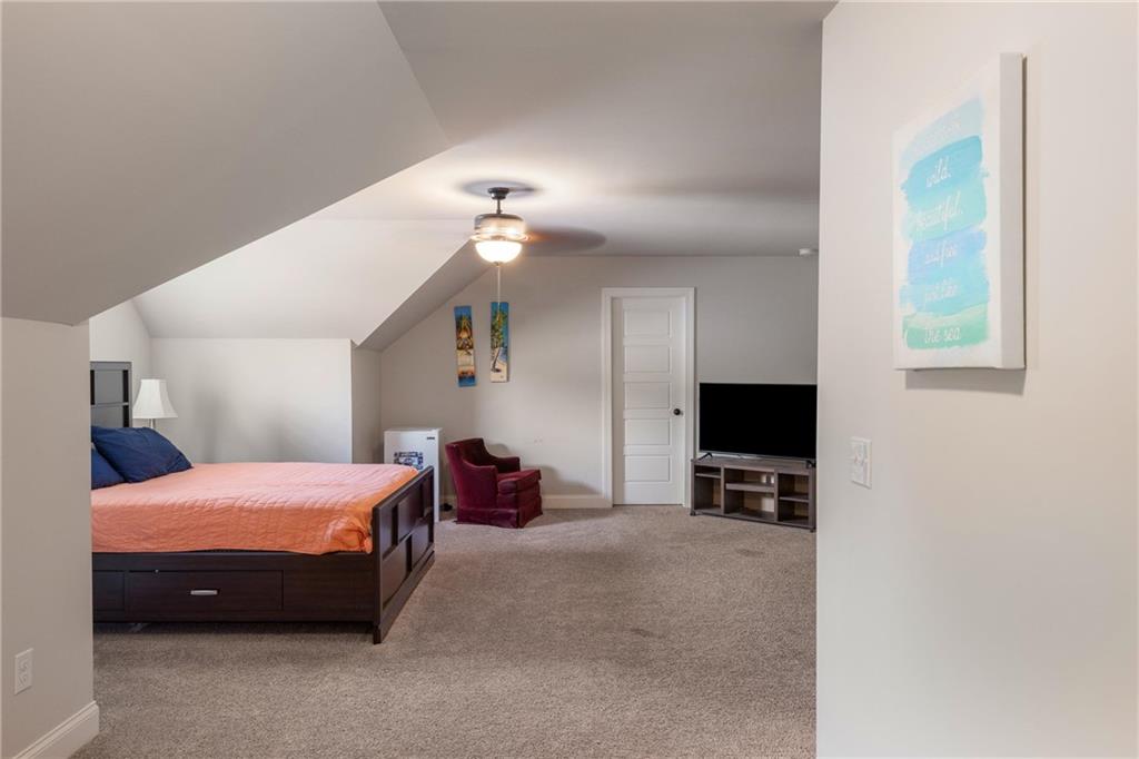 712 Fleeting Way Monroe, GA 30655 - Photo 23 of 29 a bedroom with a bed and a flat tv screen on wall