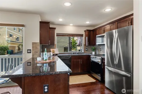 a kitchen with stainless steel appliances granite countertop a refrigerator a stove a sink and a refrigerator