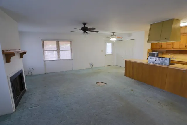 a view of a livingroom with furniture a ceiling fan and a fireplace