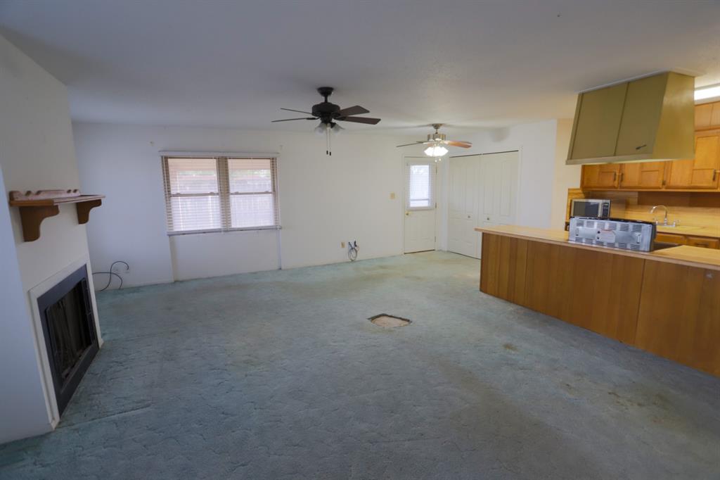 1009 Buchanan Street McGregor, TX 76657 - Photo 2 of 14 a view of a livingroom with furniture a ceiling fan and a fireplace