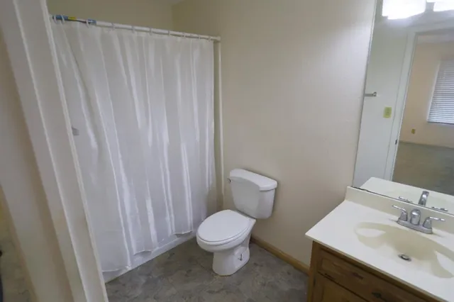 a bathroom with a toilet a sink and a mirror
