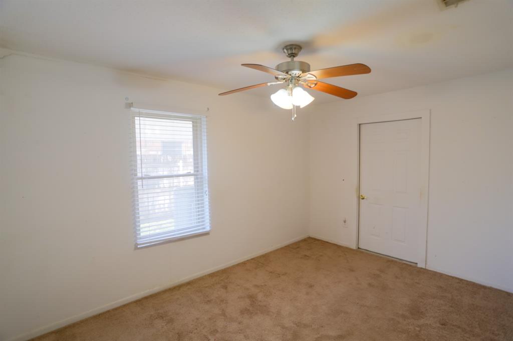 1009 Buchanan Street McGregor, TX 76657 - Photo 10 of 14 an empty room with windows and fan