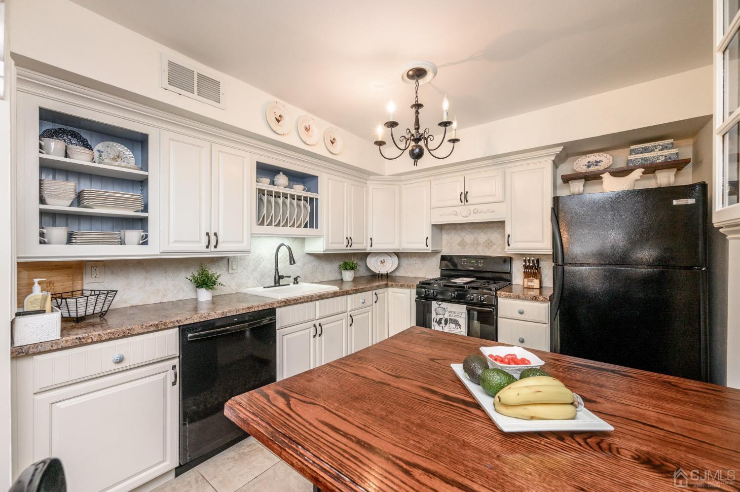 607 Randall Way Aberdeen, NJ 07747 - Photo 8 of 35 a kitchen with stainless steel appliances granite countertop a refrigerator a sink dishwasher a stove and white cabinets with wooden floor