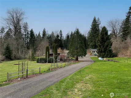 a front view of a house with a yard and trees