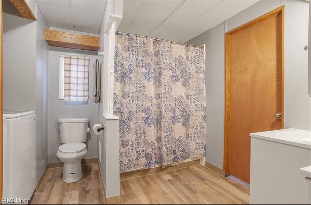 7443 Spillway Road, Unit 73 Lisbon, OH 44432 - Photo 6 of 9 Bathroom with vanity, a shower with shower curtain, and light wood-style floors
