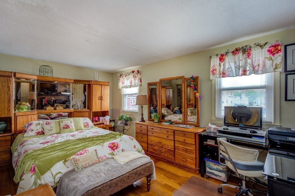 55 Jacob Street Boston, MA 02124 - Photo 11 of 22 a bedroom with a bed a large window and book shelfs