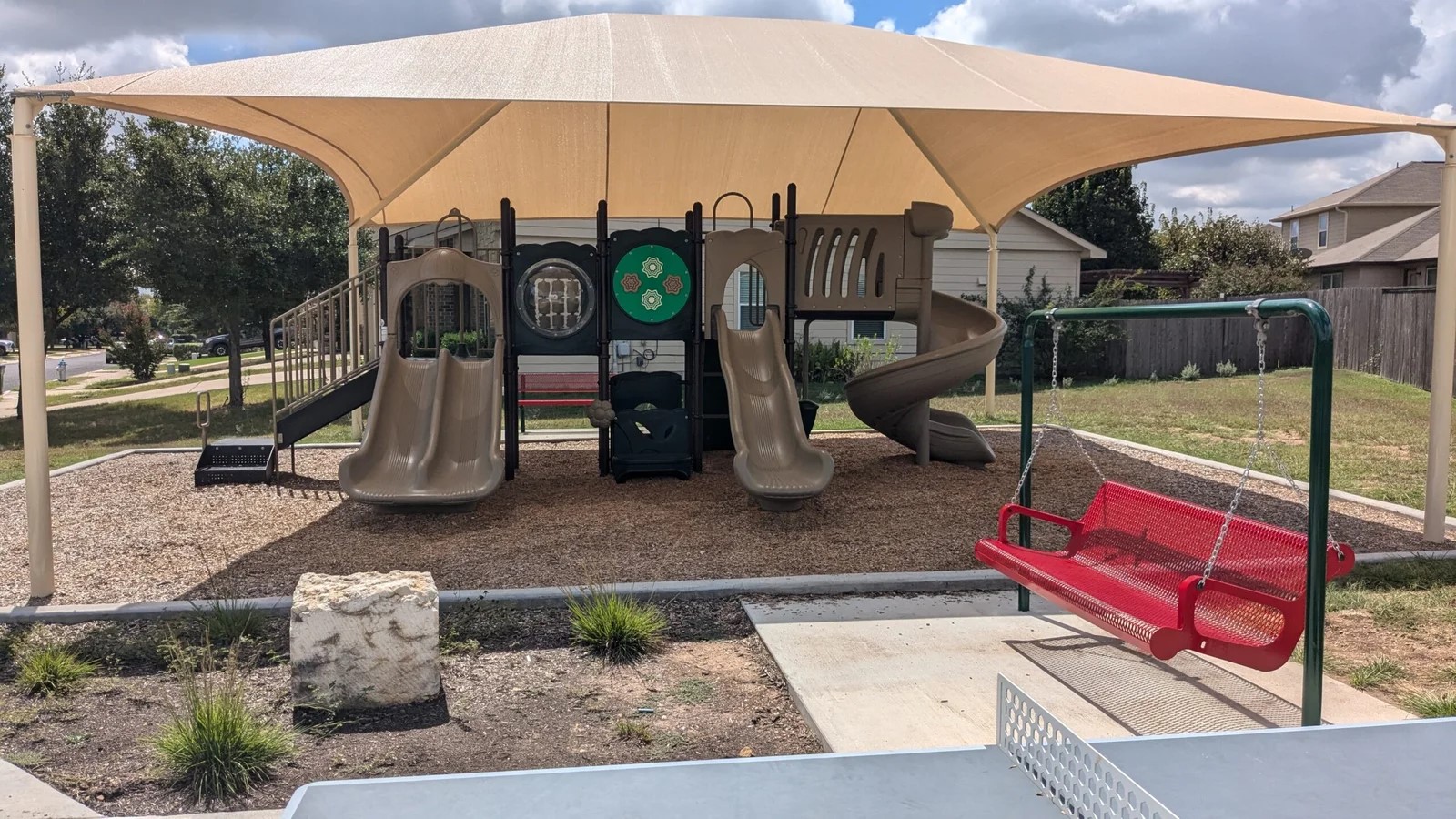 169 Marcheeta Way Leander, TX 78641 - Photo 36 of 39 This property features a playground area with a protective canopy, equipped with slides, climbing structures, and a swing set