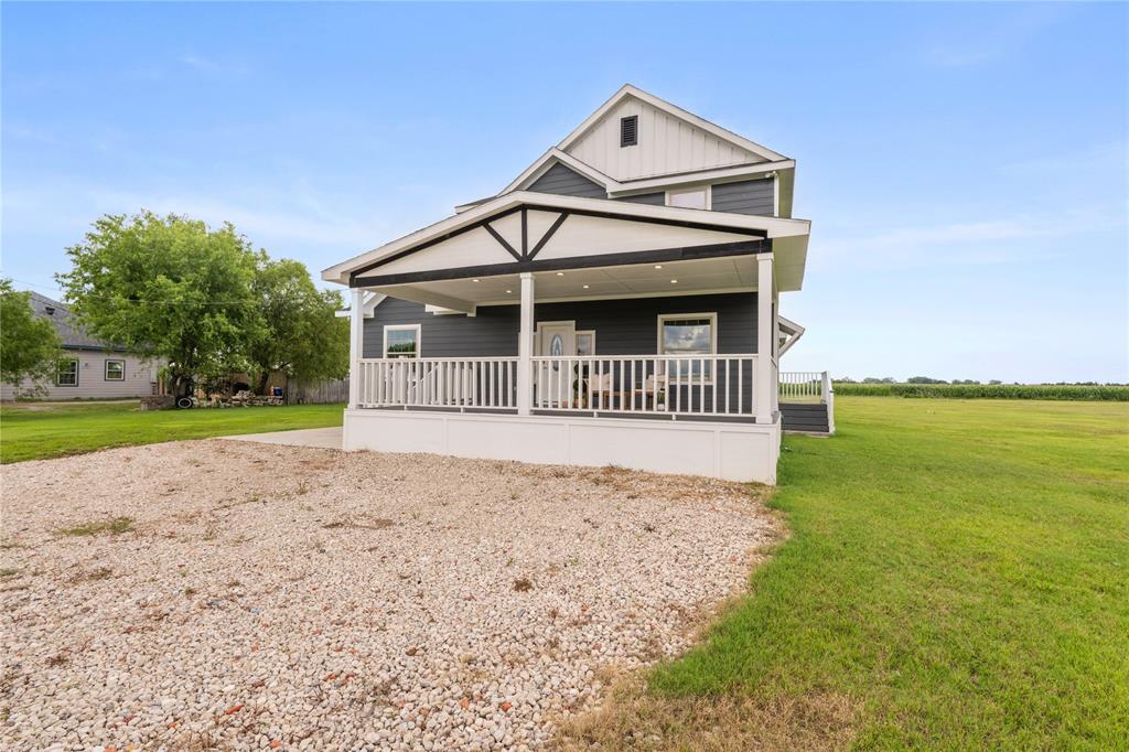 1128 Newton Road Ferris, TX 75125 - Photo 3 of 28 Two-story residence featuring dark siding, white trim, and a covered front porch with white railings