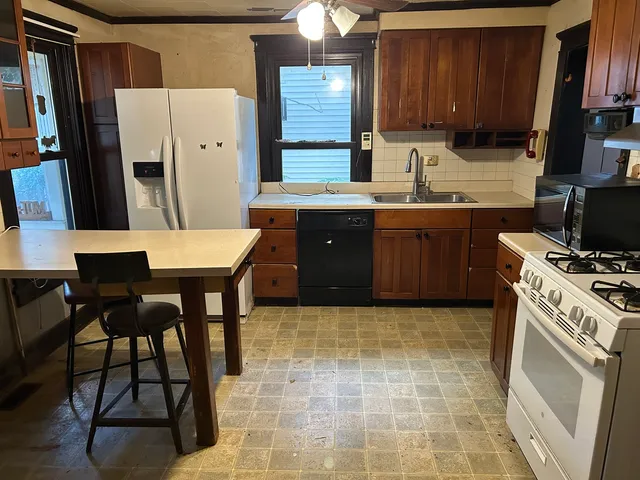 a kitchen with stainless steel appliances granite countertop a stove refrigerator sink and cabinets