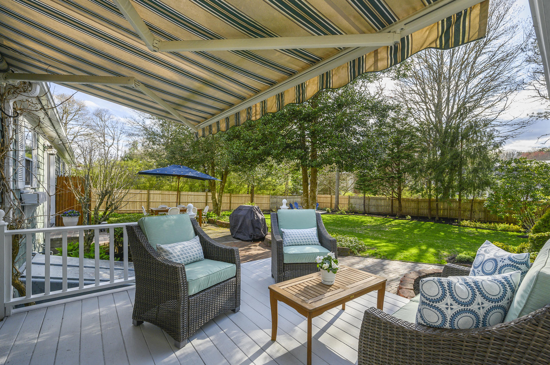 73 Knotty Pine Lane Centerville, MA 02632 - Photo 24 of 34 a view of a patio with couches and a table and chairs with wooden floor and fence