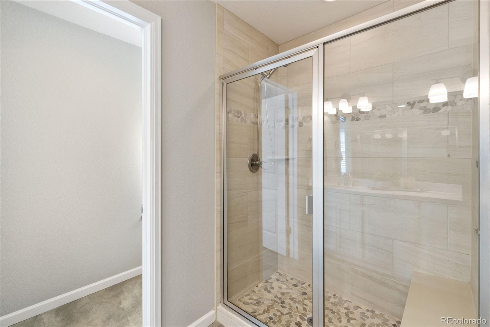 1338 Promontory Bluff View Colorado Springs, CO 80921 - Photo 16 of 28 a bathroom with a glass shower door