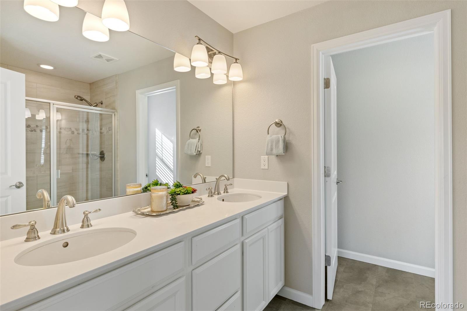 1338 Promontory Bluff View Colorado Springs, CO 80921 - Photo 6 of 28 a bathroom with double vanity sinks and a mirror