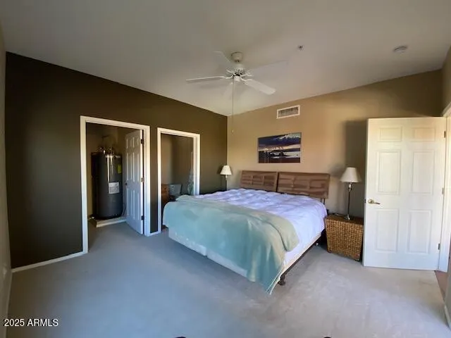 a spacious bedroom with a large bed and a chandelier