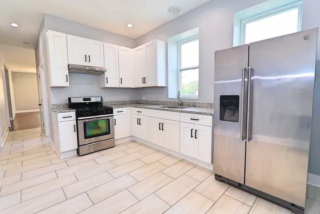 a kitchen with stainless steel appliances granite countertop a stove a sink and a refrigerator