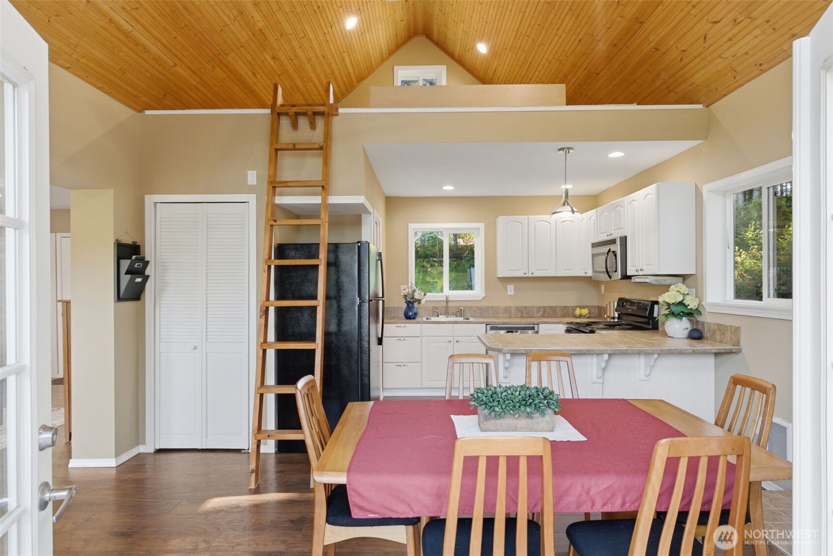 6971 Northeast Tahuya Blacksmith Road Belfair, WA 98528 - Photo 14 of 38 a kitchen with stainless steel appliances granite countertop a dining table chairs and a refrigerator