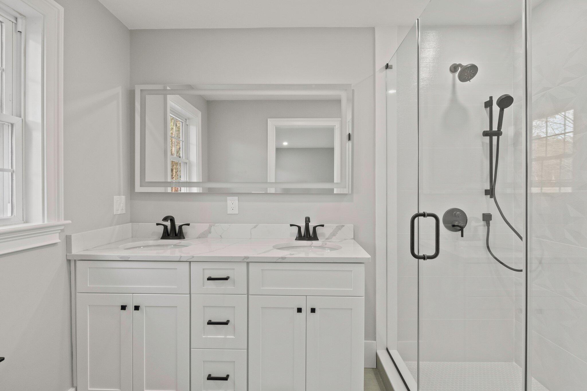 197 Old Barnstable Road Mashpee, MA 02649 - Photo 32 of 50 a bathroom with a double vanity sink and mirror