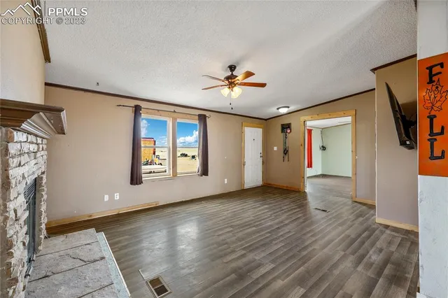 a view of an empty room with a fireplace and a window