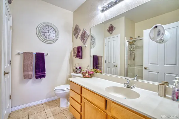 a bathroom with a granite countertop sink mirror vanity and toilet
