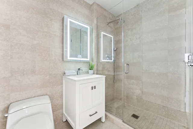 a bedroom with a bed painting on wall and a large window