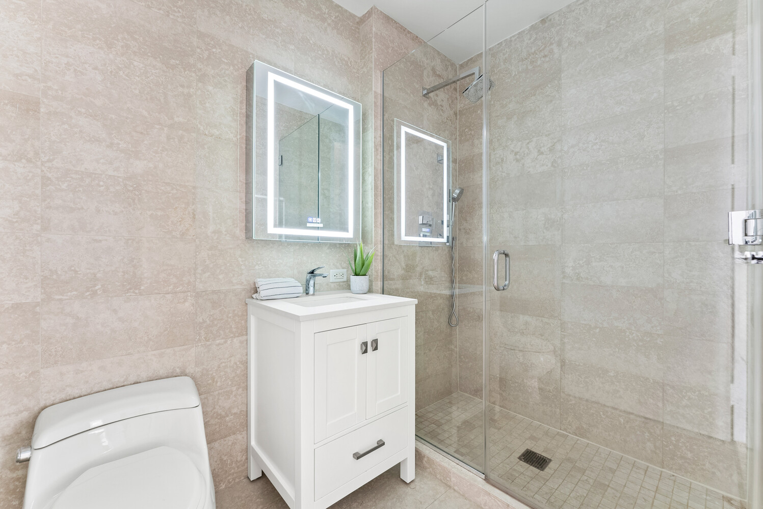 75 Wall Street, Unit 34C Manhattan, NY 10005 - Photo 11 of 26 a bathroom with a granite countertop sink a toilet and shower