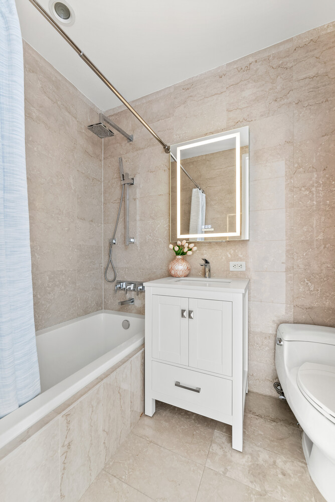 75 Wall Street, Unit 34C Manhattan, NY 10005 - Photo 14 of 26 a bathroom with a tub a sink and a shower
