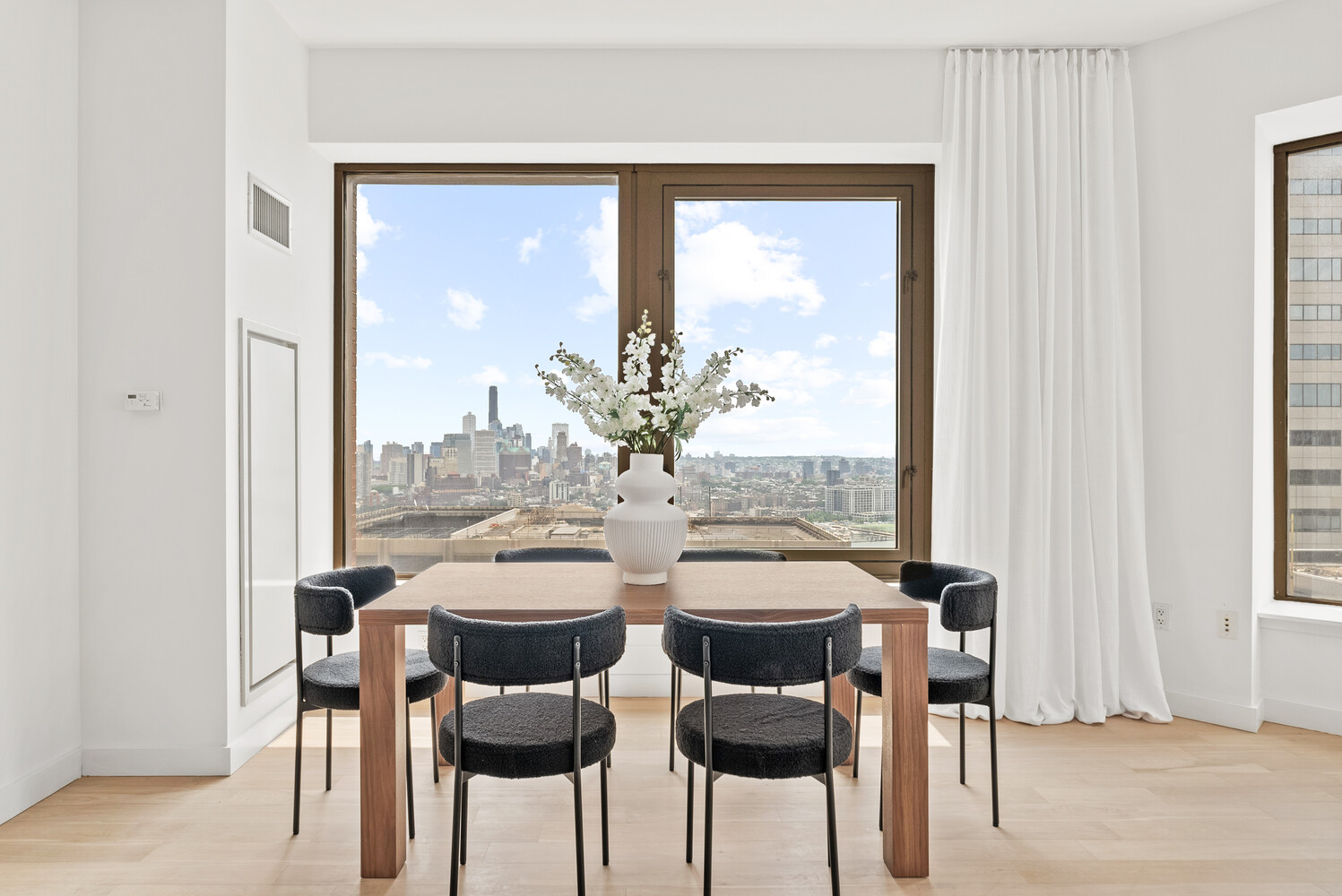 75 Wall Street, Unit 34C Manhattan, NY 10005 - Photo 4 of 26 a view of a dining room with furniture and window