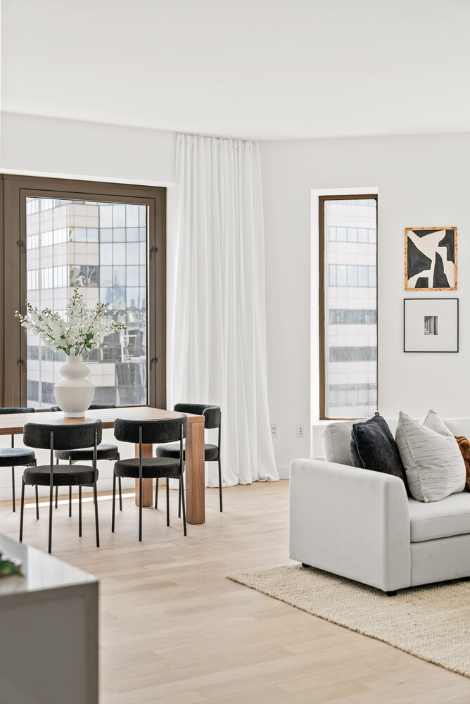 75 Wall Street, Unit 34C Manhattan, NY 10005 - Photo 5 of 26 a living room with furniture and large windows