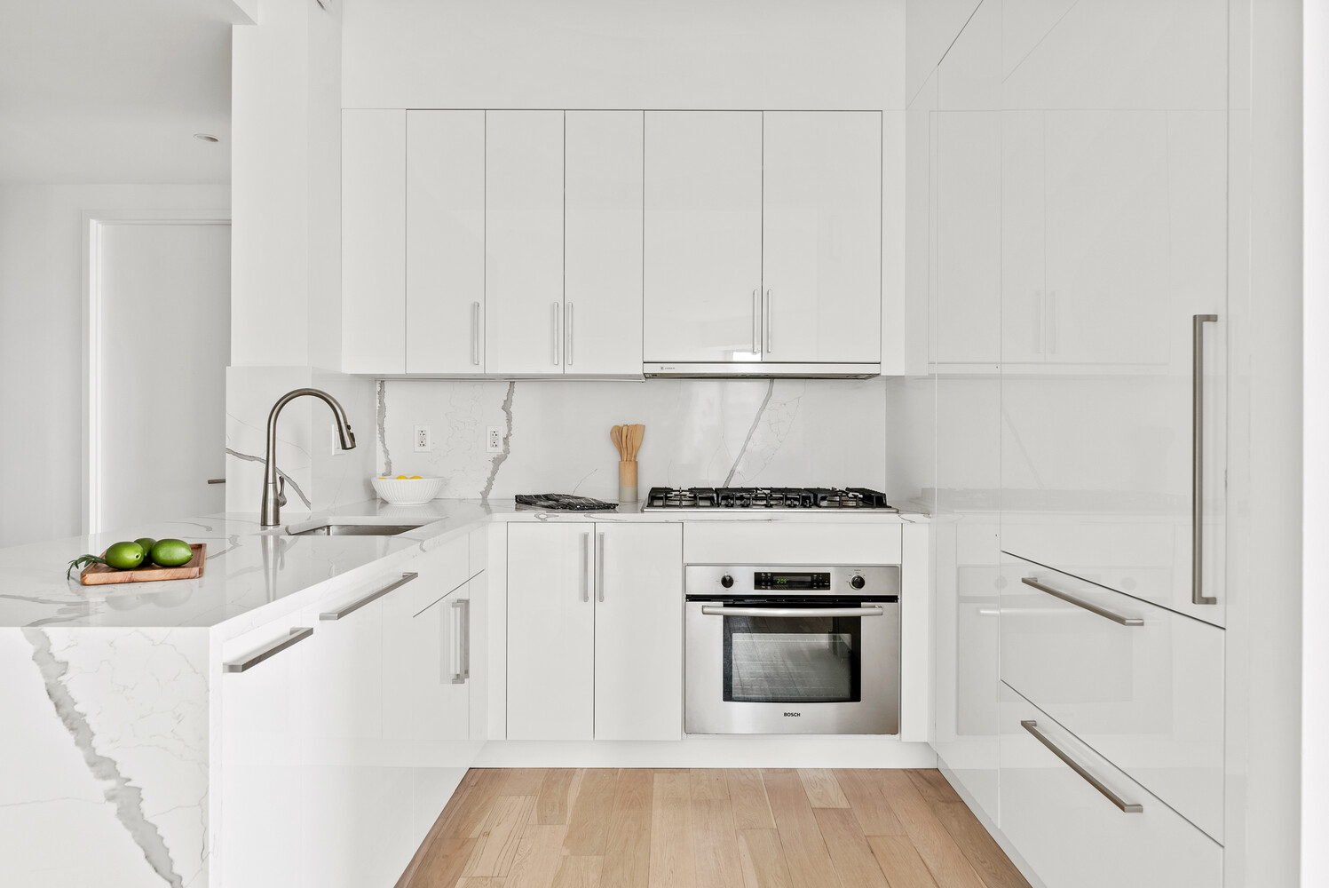 75 Wall Street, Unit 34C Manhattan, NY 10005 - Photo 6 of 26 a kitchen with white cabinets and appliances