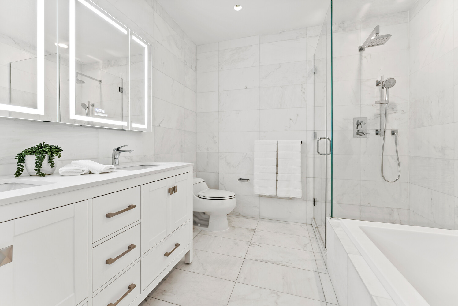 75 Wall Street, Unit 34C Manhattan, NY 10005 - Photo 9 of 26 a spacious bathroom with a granite countertop sink a toilet and a shower