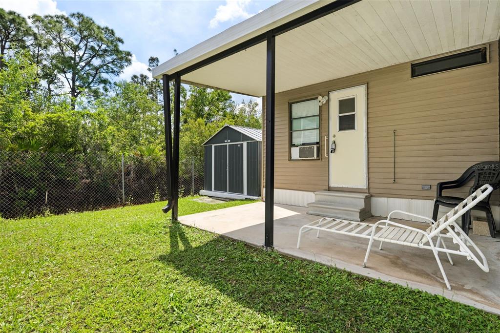 1703 North Manatee Loop Punta Gorda, FL 33950 - Photo 11 of 21 a view of a backyard with table and chairs and wooden fence