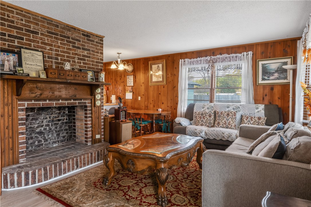 155 Farrs Bridge Road Pickens, SC 29671 - Photo 5 of 19 This living area features a charming brick fireplace, perfect for cozy gatherings and quiet evenings.