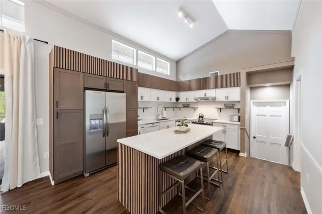 a kitchen with a dining table chairs refrigerator and cabinets