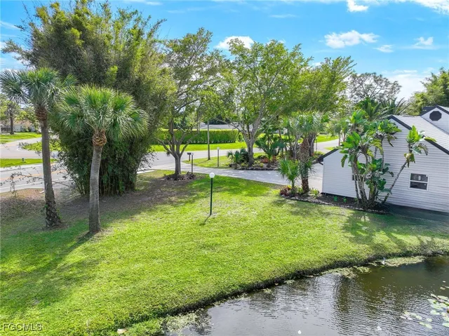 an aerial view of a house with a yard and lake view