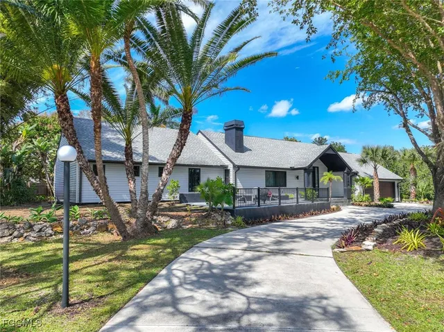 a living room with patio furniture and a potted plants